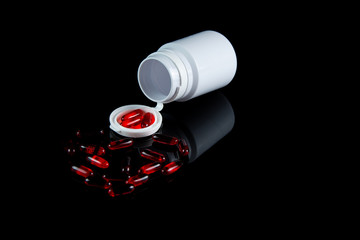 Pills spilling out of pill bottle medicine in a dark background. COVID-19 medicine concept.