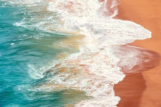 Raging ocean, azure coast with a golden sandy beach. Top view, drone view Benagil Beach in Portugal.