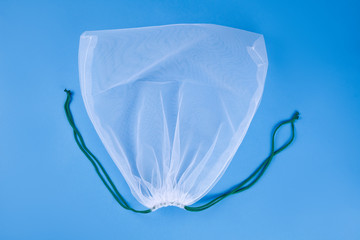Reusable eco friendly net bag on a blue background.