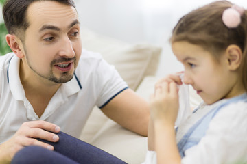 Fototapeta premium Dad is trying to calm down his daughter.