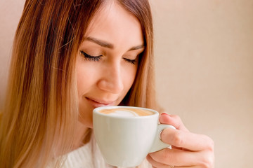 beautiful sexy blonde holds a cup of coffee. girl enjoys a delicious drink, morning ritual.