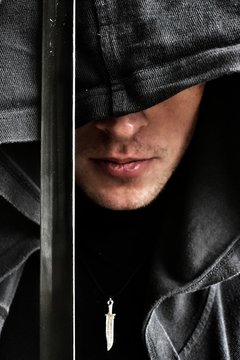 handsome young man in the hood with a sward
