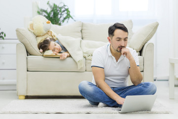 Fototapeta premium Dad texts to the mother whose daughter sleeps on his sofa.