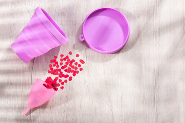 menstrual cup on the wooden table - text space