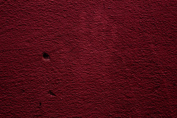 Crimson colored abstract wall background with textures of different shades of crimson and red and the imprint of a hand