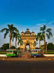 Vientiane Laos two auto rickshaws parked in front of the Patuxai Monument