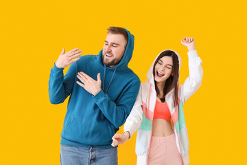 Happy young couple dancing against color background