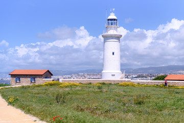Fototapeta na wymiar Lighthouse white against the blue sky. Symbol of hope and faith in the future