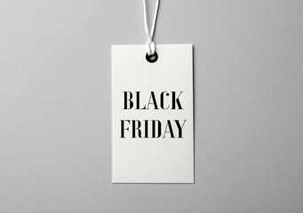 Tag with text BLACK FRIDAY on light background, top view