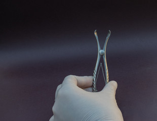 especulo nasal para examen médico de acero inoxidable sostenido por mano con guante blanco