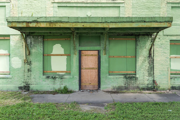 Boarded up and abandoned green factory building in the deep south of Louisiana