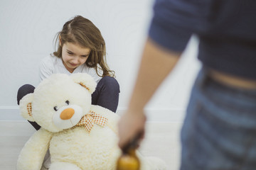 Little girl hiding behind a white bear.