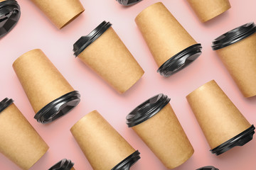 Many takeaway coffee cups on color background