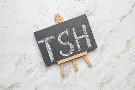 Board with abbreviation TSH on white background