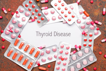 Text THYROID DISEASE with pills on color background