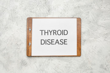 Clipboard with text THYROID DISEASE on light background