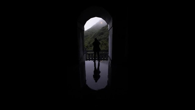 Hombre atravesando una ventana de campanario con lluvia en d&iacute;a nublado