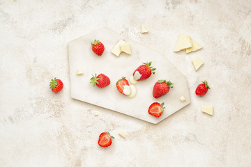 Board with tasty strawberry and melted chocolate on light background