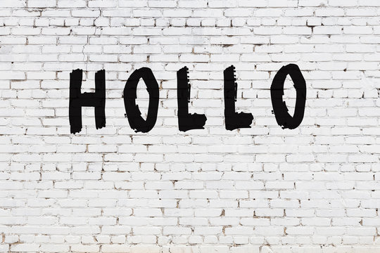 Word hollo painted on white brick wall
