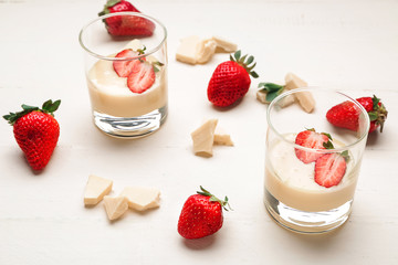Glasses with tasty strawberry and melted chocolate on white table