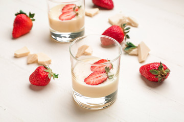 Glass with tasty strawberry with melted chocolate on white table