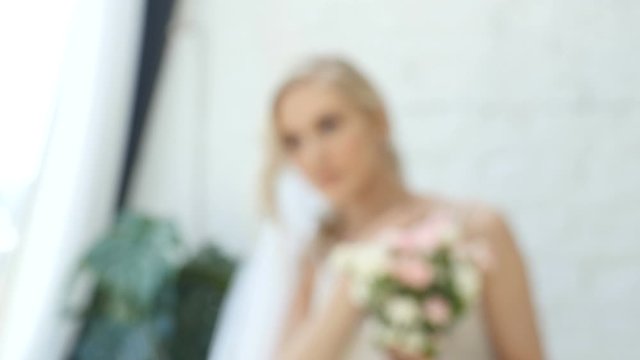 Bokeh shot, young woman, bride posing for photo in studio, natural light, blonde beautiful girl is posing