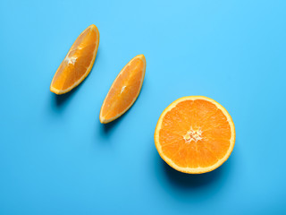 Fototapeta premium Half of an orange on colorful blue surface