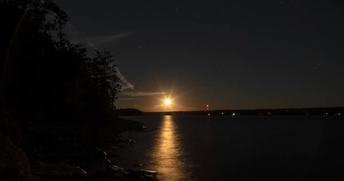 Timelapse of moon setting over Shubenacadie Grand Lake in Laurie Provincial Park Nova Scotia Canada and revealing the milky way. Includes 2 versions, 1 static and 1 with a digital tilt up.