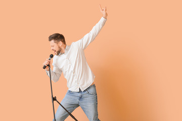Handsome man singing against color background