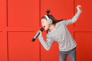 Cute little girl singing against color background