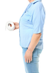 Elderly woman with toilet paper suffering from hemorrhoids on white background