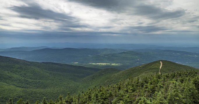 Time lapse from the top of Canon Mountain mid day in New Hampshire USA. Clouds flying overhead with view of some farms far below. Includes 2 versions, one tilting down and 1 stationary.