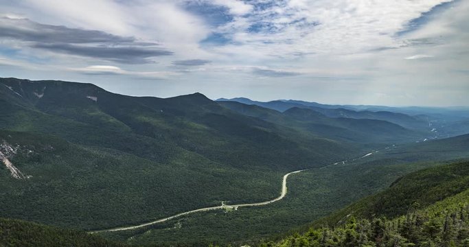 Time lapse from the top of Canon Mountain mid day in New Hampshire USA. Clouds flying overhead with view of the highway far below. Includes 2 versions, one tilting up and 1 stationary.