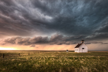 A severe thunderstorm approaches an old abandoned church in the countryside during the late...
