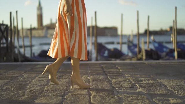 low angle shot of a woman walking along a Venice canal