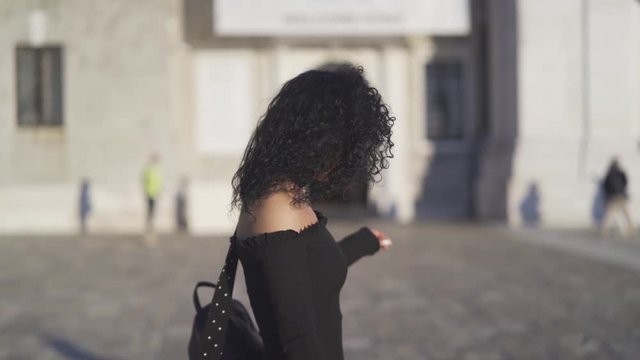 Beautiful italian woman walking in front of a square in slow motion