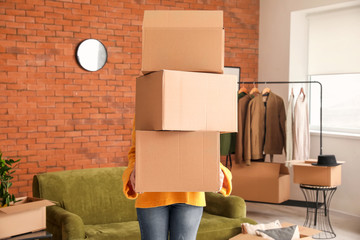 Fototapeta na wymiar Woman with belongings in cardboard boxes on moving day