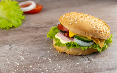delicious sandwich for breakfast on a wooden table sprinkled with sesame seeds