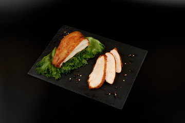 Grilled chicken fillet and vegetables on stone plate