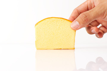 Man hand holding a piece of sliced butter cake isolated on white background,sweet bakery. Cut soft delicious pastry.