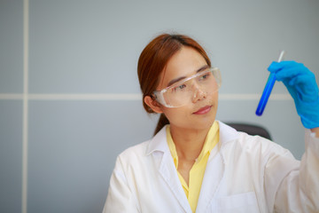 Closeup scientist holding conical tube with liquid solution, laboratory experiments