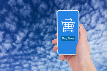 Under the blue sky, close-up of a man's hand holding a mobile phone for online shopping.