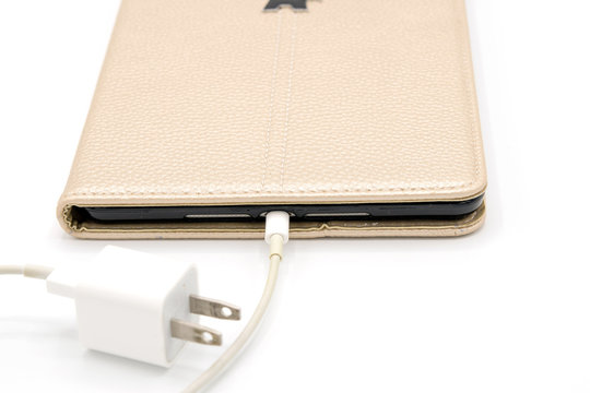 Tablet PC With Brown Case With Transformer On White Backdrop.