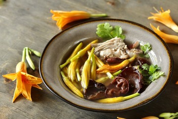 Asian soup with daylily flowers (golden needles), woody ear mushrooms and pork. Chinese cuisine. young daylily buds, edible flowers, foraging. daylily recipe