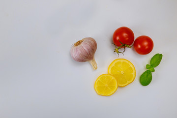 Lemon, tomato, garlic and basil on white background.