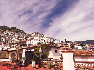 Taxco de Alarcon, Guerrero, Mexico. Picturesque magical town, with white-walled houses, red roofs, and balconies adorned with multi-colored flowers. Located on a hill. Ideal place to rest. Life style.