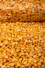 yelloYellow split peas in a plastic bag and cereal in bulk on a background of burlap with a rough texture. Traditional cereals for making soups and porridge. Close up.w crushed peas