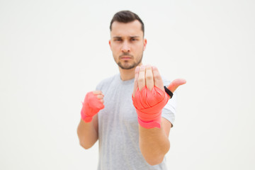 Unfocused man provoking for fight. Guy with wrapped hands wishing for boxing with you. Invitation...