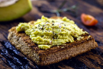 avocado pate on hot toast, with spices and spices, with vegan bread made from organic yeast. 100% vegan food.