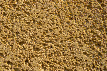 texture of yellow porous stone with shadows